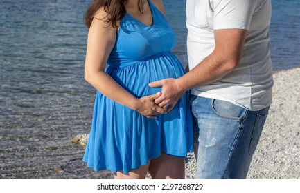 Pregnant Woman And Man Husband Lover On Pebbles Lake Beach Hug Holding With Hands The Big Advanced Belly.couple With 3d Scan Ultrasound Picture Of Unborn Yet Baby.awaiting Expecting Pregnancy Period 