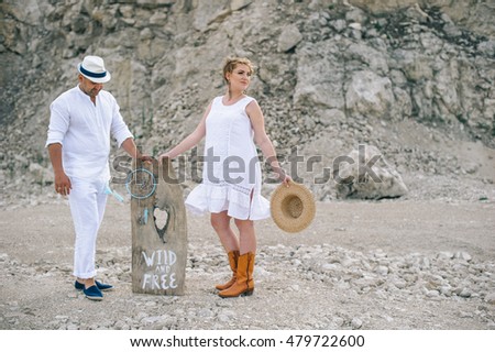 Pregnant woman and man sitting on rock