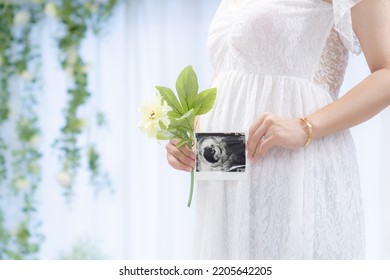 A pregnant woman in a maternity dress with an ultrasound photo (shooting a real full-term pregnant woman) - Shutterstock ID 2205642205