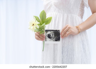 A Pregnant Woman In A Maternity Dress With An Ultrasound Photo (shooting A Real Full-term Pregnant Woman)