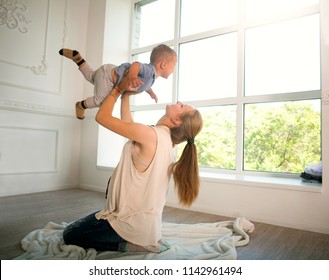 Pregnant Woman Mother And Child Playing At Home Lift Up Baby Son 