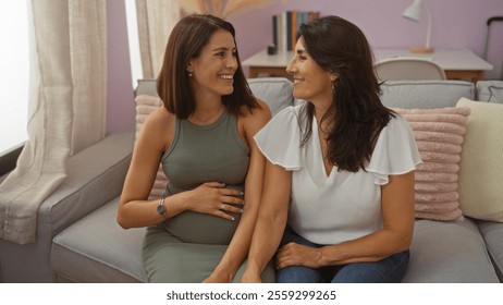 Pregnant woman and mother sitting together on a sofa at home in a loving and cozy living room, sharing a tender moment and smiles between family members. - Powered by Shutterstock