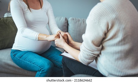 Pregnant woman on home counselling meeting. You're not in this alone. Depressed pregnant woman consultation with psychologist. Psychiatrist holding hands patient,such as making a fresh start 