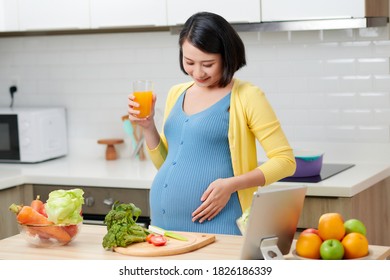 pregnant woman on kitchen drinking healthy fruit juice - Powered by Shutterstock