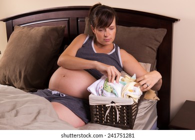 Pregnant Woman Organizing Baby Clothes