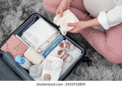 Pregnant woman packing her suitcase before going to hospital to have a baby - Powered by Shutterstock