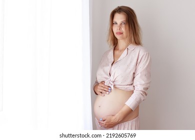 Pregnant Woman In Pajamas At The Window