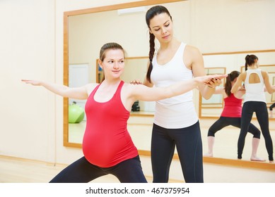 pregnant woman with personal trainer doing fitness exercise