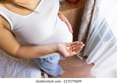 Pregnant Woman Pills Vitamin. Happy Smiling Woman Taking Pill With Supplement Vitamin Omega 3. Vitamin D, E, A Fish Oil Capsules