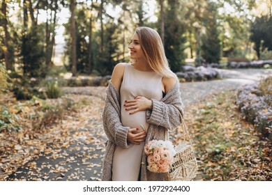 Pregnant woman posing in the park. Walking on the park. Professional make-up. Happy and carefree pregnancy. Autumn park. Free happy woman enjoying nature. - Powered by Shutterstock