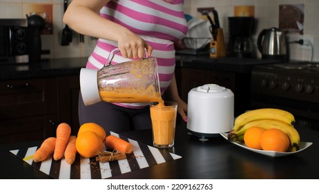 Pregnant Woman Pouring Healthy Drink in the Kitchen, Making Smoothie with Blender - Powered by Shutterstock