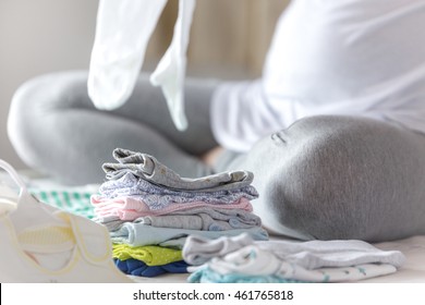 Pregnant Woman Is Preparing Baby Clothes 