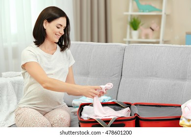 Pregnant Woman Preparing Baby Clothes