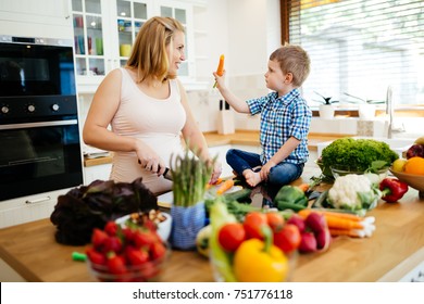 Pregnant woman preparing meal with son