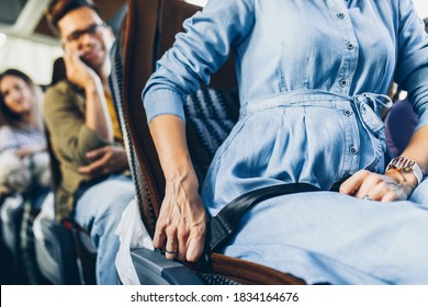 Pregnant Woman Putting On Seat Belt And Traveling In Bus.