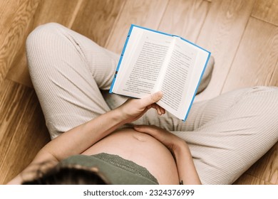 A pregnant woman is reading a book. Rest, tranquility and relaxation during pregnancy, hobbies, free time. - Powered by Shutterstock