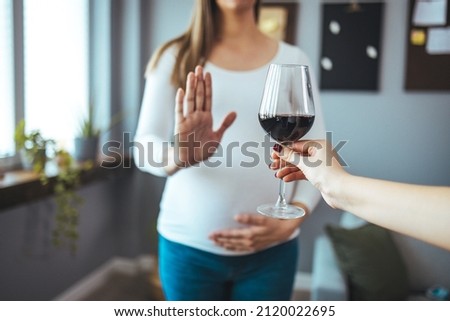 Pregnant woman refusing a glass of wine. Alcohol In Pregnancy. Unrecognizable Expectant Lady Gestring Stop To Offered Glass Of Wine