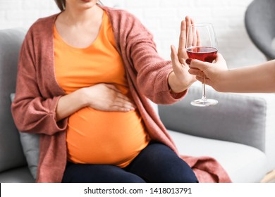 Pregnant woman rejecting alcohol at home