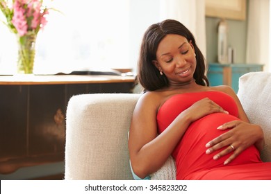 Pregnant Woman Relaxing On Sofa At Home