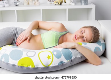 Pregnant Woman Resting On The Couch With Pillow