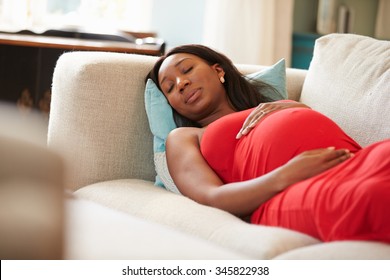 Pregnant Woman Resting On Sofa At Home