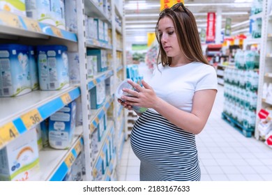 Pregnant Woman Shopping Baby Formula. Young Pregnant Woman Buying Infant Baby Formula Milk On Supermarket Background. Shopping Child Food Supermarket Concept