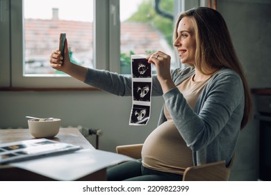 Pregnant Woman Showing Her Baby Ultrasound Photo On A Video Call