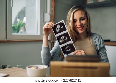 Pregnant Woman Showing Her Baby Ultrasound Photo On A Video Call