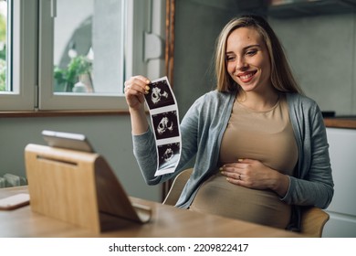 Pregnant Woman Showing Her Baby Ultrasound Photo On A Video Call