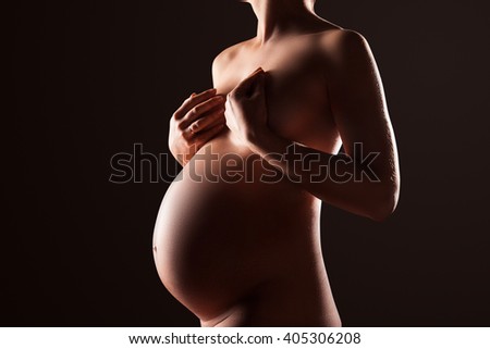 Pregnant woman silhouette over black background