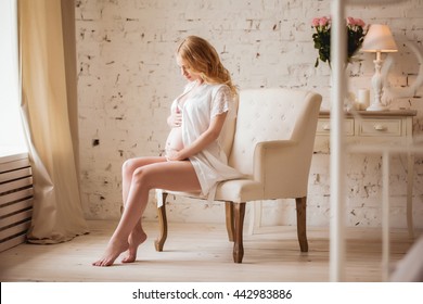 Pregnant woman sits on a chair