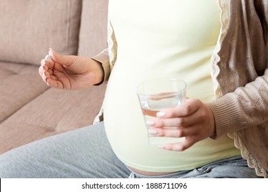 Pregnant Woman Is Sitting In Sofa. Taking Pills From Colds. Last Months Of Pregnancy.