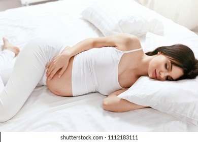 Pregnant Woman Sleep. Girl Sleeping With Pillow On Bed