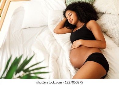 Pregnant woman sleeping in bedroom at home