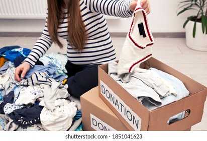 Pregnant woman is sorting baby clothes and wanna give some things to charity - Powered by Shutterstock