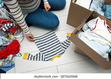 the pregnant woman is sorting baby clothes - Powered by Shutterstock