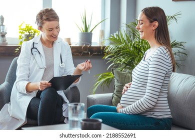 Pregnant Woman Speaks With Her Doctor At A Check-Up. A Woman Discuses Her Prenatal Health During A Routine Check Up With Her Obstetrician. 