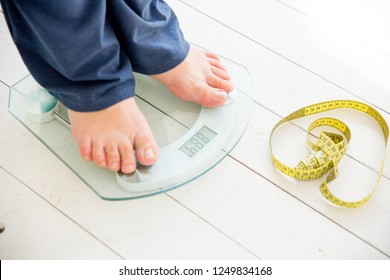 pregnant woman standing on scales to control weight gain - Shutterstock ID 1249834168