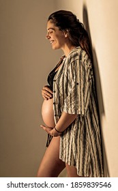 Schwangere auf einer Mauer stehen und lachen