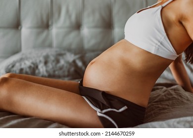 Pregnant Woman Stretching In Bed. Portrait During Pregnancy, Beautiful Bump Portrait. Prenatal Stretch Exercise