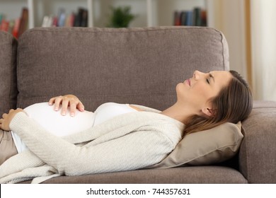 Pregnant Woman Suffering Belly Ache Lying On A Sofa At Home