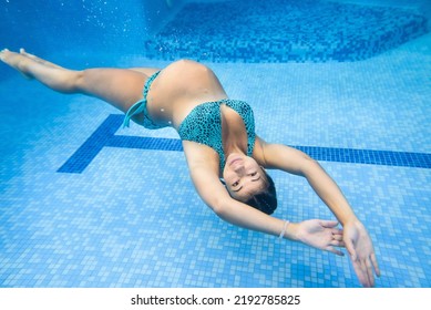 Pregnant Woman Swim, Dive In Swimming Pool. Aqua Fitness Healthcare Classes For Pregnancy. Underwater Picture Of Pregnant Woman Wearing Fashion Swimsuit In Blue Deep Pool. Aquatic Therapy Workout.