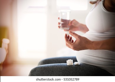 Pregnant Woman Taking Pill Against Heartburn