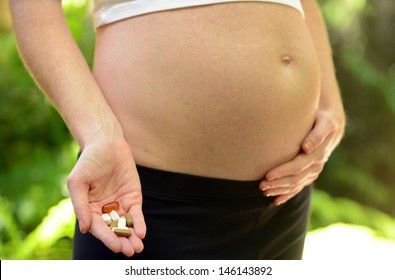 Pregnant Woman Taking Prenatal Vitamins, Fish Oil And Supplements During Pregnancy