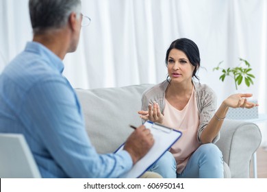 Pregnant Woman Talking To Doctor At Home