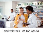 Pregnant woman talking to female pharmacist at pharmacy