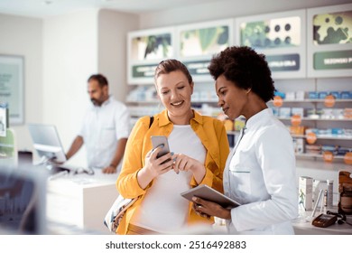 Pregnant woman talking to female pharmacist at pharmacy - Powered by Shutterstock