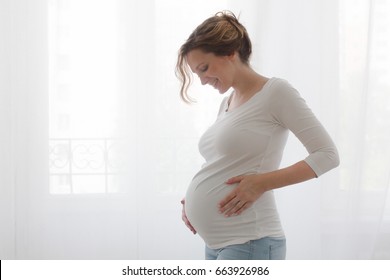 Pregnant woman touching belly - Shutterstock ID 663926986