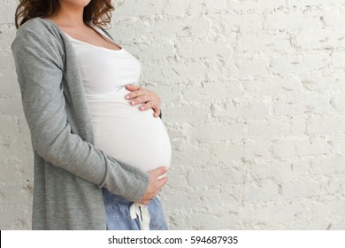 Pregnant woman touching belly close-up