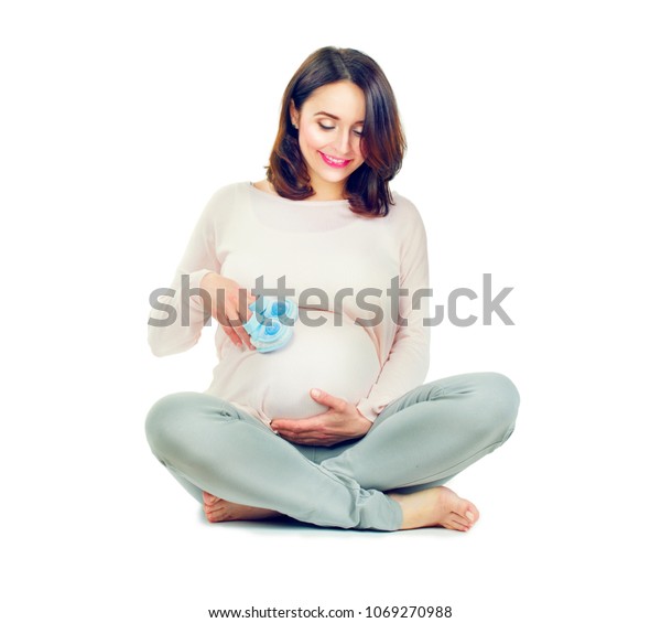 妊娠中の女性がお腹を触って 妊娠中年の母親の手がおなかを愛撫する 白い背景に健康的な妊娠のコンセプト 座るグラビッドの女性 全長のポートレート の写真素材 今すぐ編集